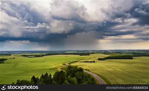 Storm dark clouds over field. Thunderstorm over a wheat field. Rural scene in Belarus, Europe