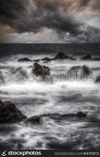 Storm in the ocean. Stones in the water are shot on a long exposure. Storm in the ocean.