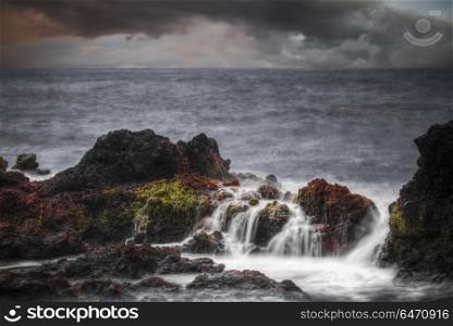 Storm in the ocean. Stones in the water are shot on a long exposure. Storm in the ocean.