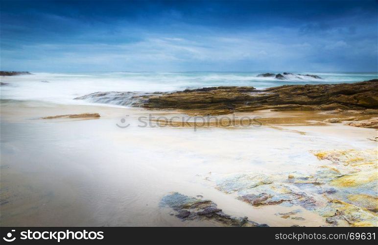 Stormy beach landscape time-lapse with smooth waves and rocks