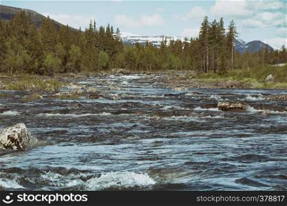 stormy mountain river on a background of snowy mountains, Norway