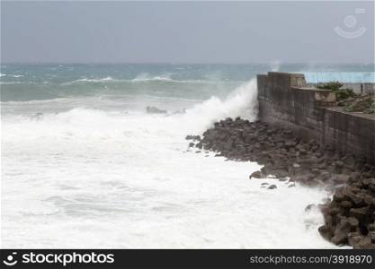 Stormy sea during Typhoon Souledor. waves crashing on barrier wall