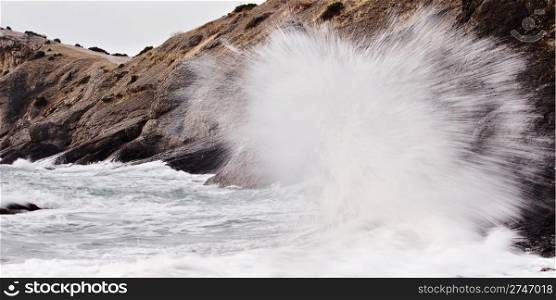 Stormy sea with crashing waves on rocks