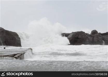 Stormy sea with waves crashing on rocks during Typhoon Souledor