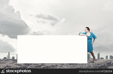 Stout woman with banner. Stout confident woman of middle age with blank white banner