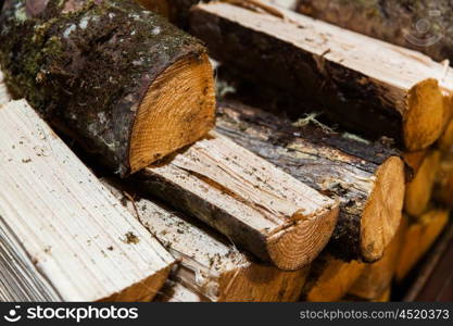 stove heating, fuel and wood concept - close up of firewood pile