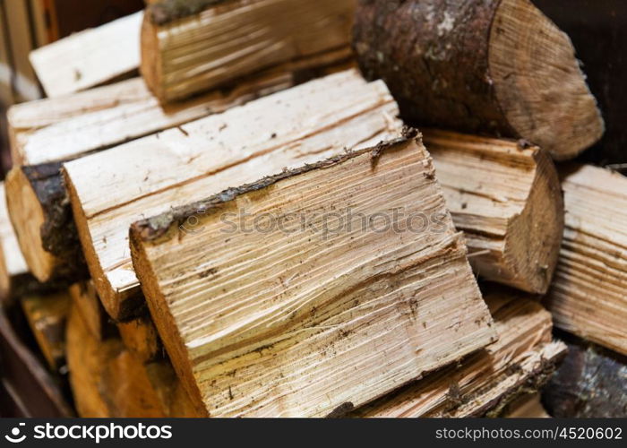 stove heating, fuel and wood concept - close up of firewood pile