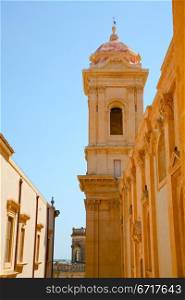 straight baroque style street with houses from yellow sandstone in Noto, Sicily