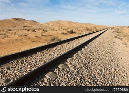 Straight railway in the desert to the horizon
