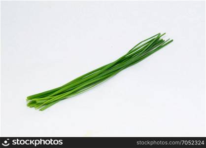 Strands of fresh chives . Strands of fresh chives on a white background