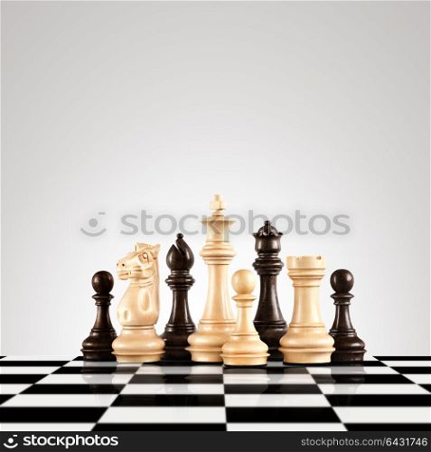 Strategy and leadership concept; black and white wooden chess figures standing on the board ready for game.