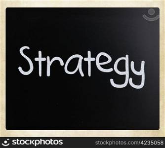 ""Strategy" handwritten with white chalk on a blackboard."
