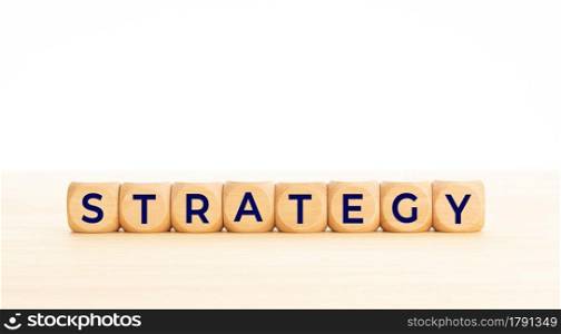 Strategy word in wooden blocks on table. White background. Copy space
