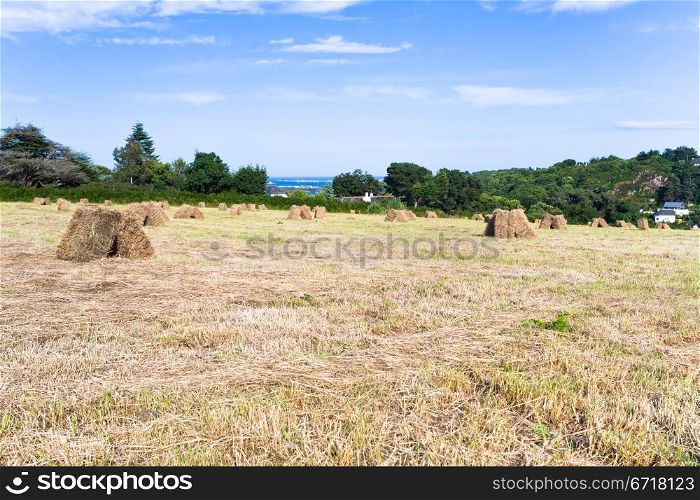 straw stack in field near small Breton village