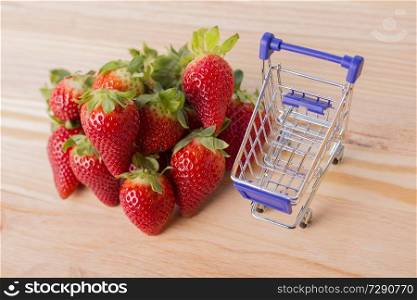 strawberries and a shopping cart on garden&rsquo;s table, outdoor picture