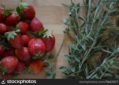 strawberries and herbs on a wood cutting board