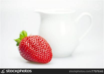 strawberries and milk jug isolated on white