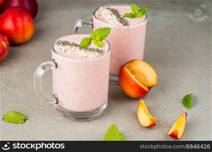 Strawberries and peaches smoothie in glass jars on concrete countertop. Protein cocktail. Healthy drink. Fresh homemade smoothie. Healthy breakfast of smoothie.