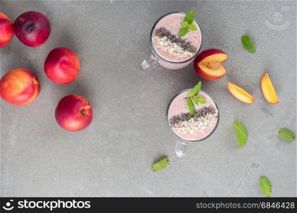 Strawberries and peaches smoothie in glass jars on concrete countertop. Protein cocktail. Healthy drink. Fresh homemade smoothie. Healthy breakfast of smoothie.
