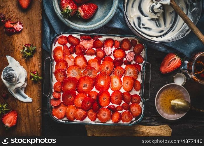 Strawberries cake, cooking preparation with ingredients and kitchen tools, top view