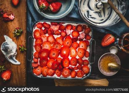 Strawberries cake, cooking preparation with ingredients and kitchen tools, top view