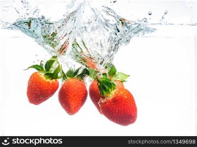 Strawberries falling into water causing bubbles all around it. Healthy food concept. Underwater, splash photography.. Strawberries falling into water causing bubbles all around it. Healthy food concept