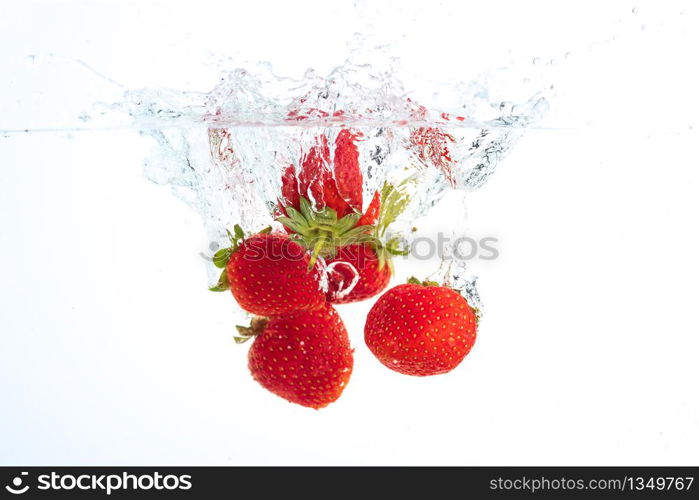 Strawberries falling into water causing bubbles all around it. Healthy food concept. Underwater, splash photography.. Strawberries falling into water causing bubbles all around it. Healthy food concept