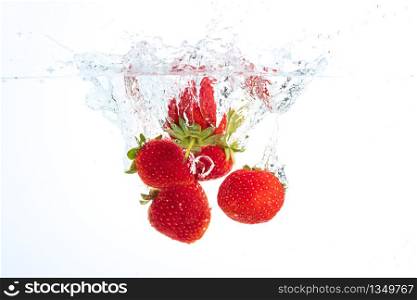 Strawberries falling into water causing bubbles all around it. Healthy food concept. Underwater, splash photography.. Strawberries falling into water causing bubbles all around it. Healthy food concept