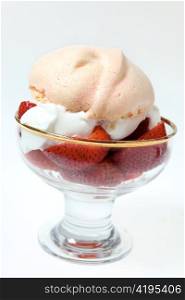 Strawberries in a bowl with whipped cream and a pink meringue