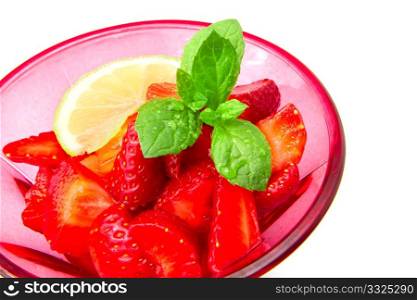 Strawberries in a cup decorated with a lemon on white background