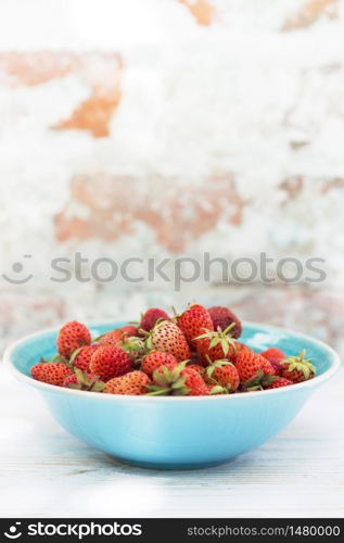 Strawberries in bowl on a wooden table