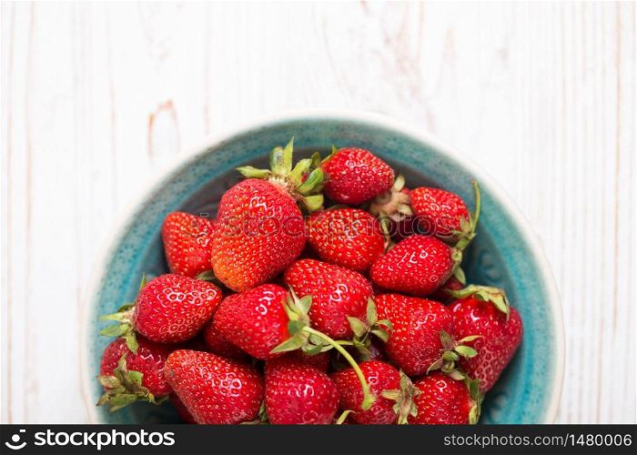 Strawberries in bowl on a wooden table