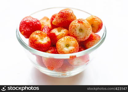 Strawberries in glass bowl isolated on white background.