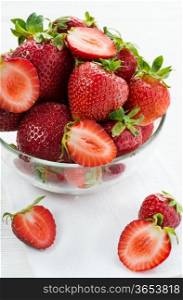 Strawberries in glass bowl on white background, selective focus, close up