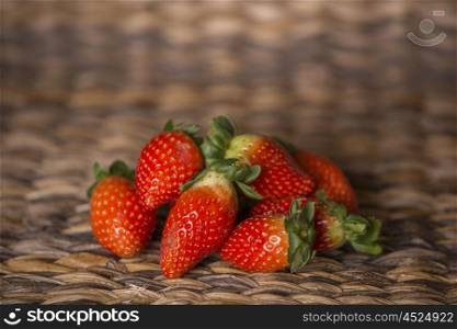 strawberries on wooden table in front of a wooden background