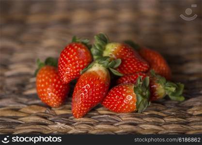 strawberries on wooden table in front of a wooden background