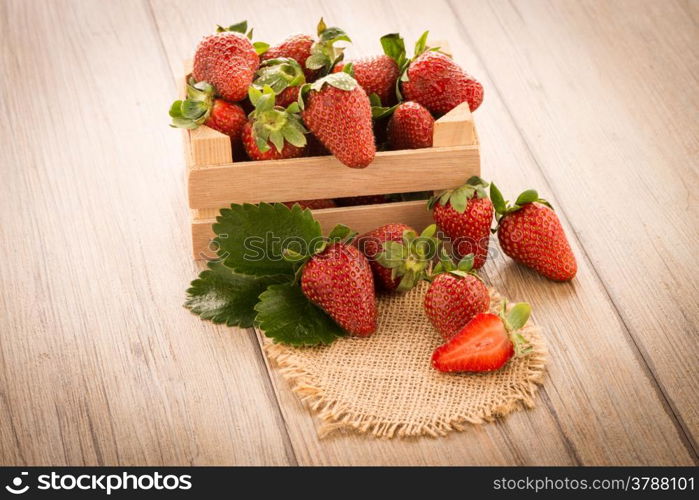 Strawberries over odl brown wooden table background