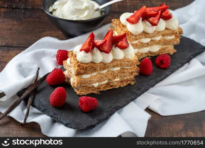 Strawberries, raspberry and Cream Mille Feuille dessert on black stone plate