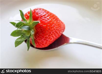 Strawberries with leaves on a plate in a glas bowl. Isolated on a white background