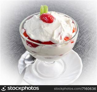 Strawberries with whipped cream in a glass bowl. Strawberries with whipped cream in a glass bowl on dark background