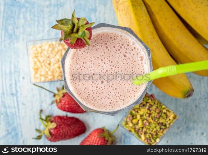 Strawberry and banana cold smoothie on blue background