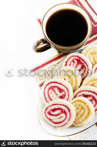 Strawberry and lemon jam swiss roll with cup of coffee isolated on white, copy space, selective focus