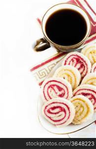 Strawberry and lemon jam swiss roll with cup of coffee isolated on white, copy space, selective focus