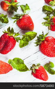 Strawberry and mint over white shabby wooden board. Strawberry and mint