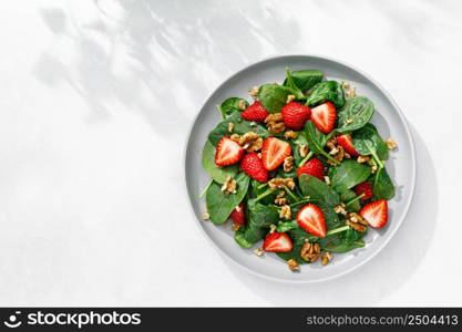 Strawberry and spinach salad with walnuts, top view