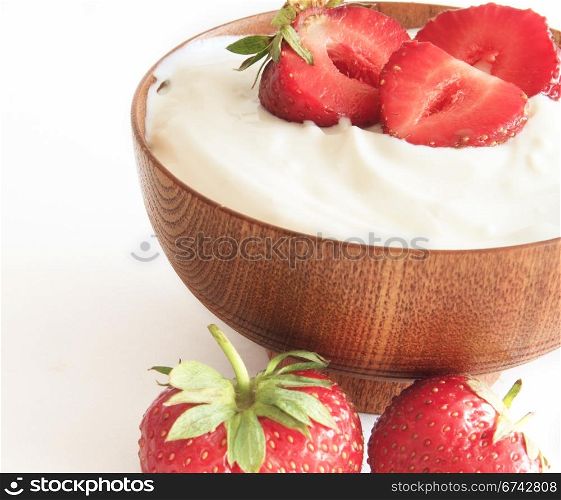 strawberry and yogurt in a wooden bowl