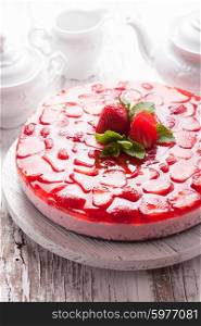Strawberry cake on white wooden plate with mint leaf. Strawberry cake