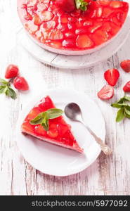 Strawberry cake on white wooden plate with mint leaf. Strawberry cake