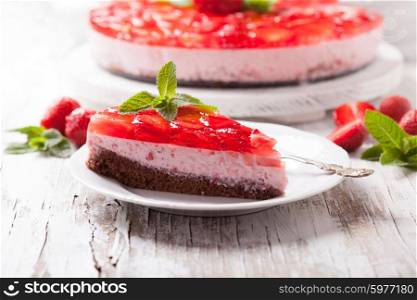 Strawberry cake on white wooden plate with mint leaf. Strawberry cake