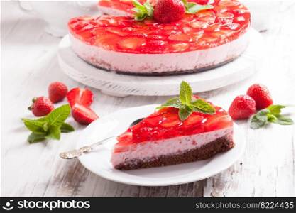 Strawberry cake on white wooden plate with mint leaf. The Strawberry cake
